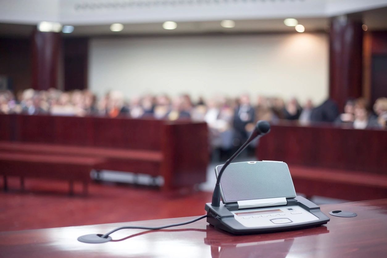 Microphone and speaker at a podium with blurred audience in background